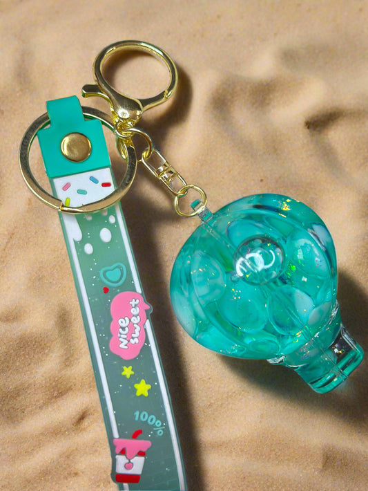 A hot air balloon-shaped clear keychain with mint green bubbles and glitter inside, attached to a mint silicone strap labeled "Nice Sweet."